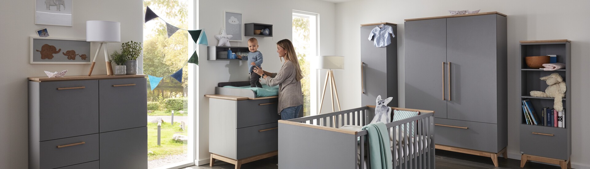 Möbel GUNST Headerbild zum Thema Kinderzimmer: Frau steht mit Baby an einem Wickeltisch in einem Kinderzimmer.