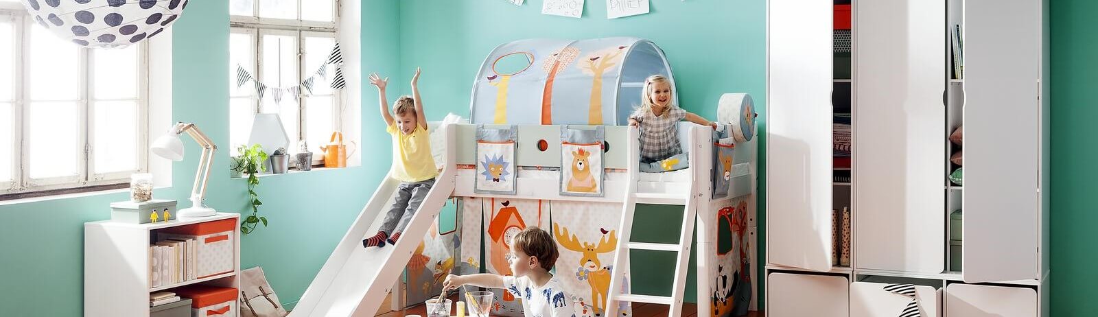 Headerbild für Baby-, Kinder- und Jugendzimmer: Spielende Kinder auf einem Spiebett mit Rutsche