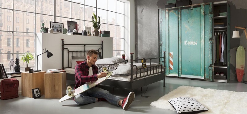 Jugendzimmer imer Industrial-Desing mit Metallbett und Schrank im Cargo-Look.