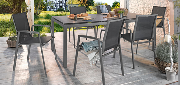 Graue Gartenstühle an einem Tisch auf einer Terrasse