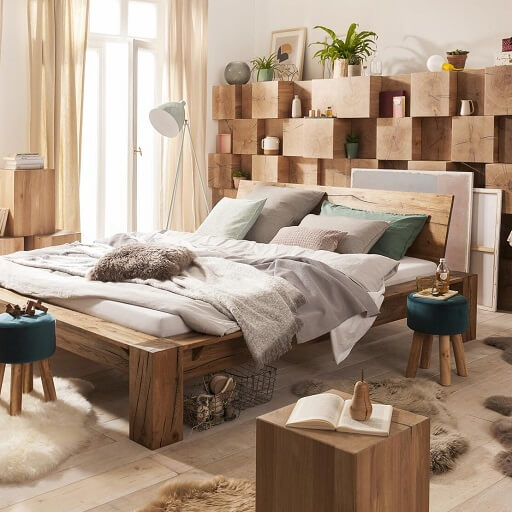 Massivhiolz-Bett vor einer Fächer-Holzwand