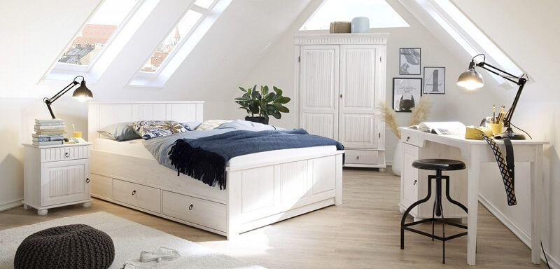 Schlafzimmer-Einrichtung in weißem Landhaus-Stil im Dachboden.