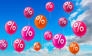 Bunte Luftballons mit Prozentzeichen steigen in einen blauen Himmel.