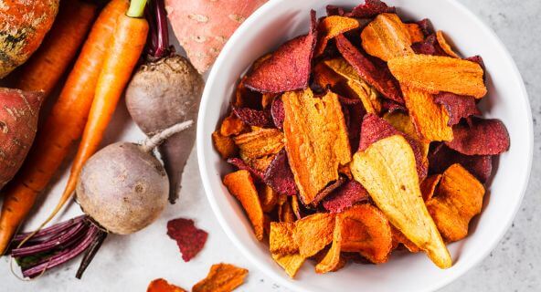 Knusprige Gemüsechips aus Karotten, Rote Bete und Süßkartoffeln in einer weißen Schüssel