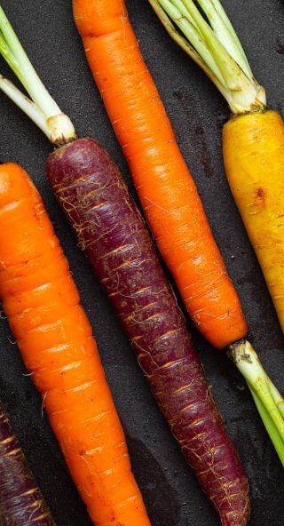 Bunte Karotten in Orange und Lila als Zutat für knusprige Gemüsechips aus dem Backofen mit integriertem Airfryer.