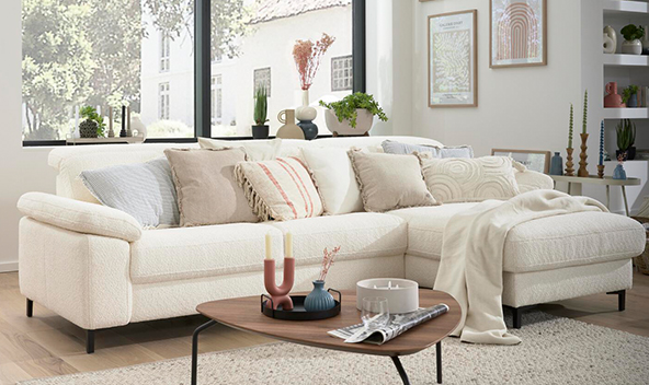 Pure Living legt den Fokus auf das Wesentliche: Ein helles Sofa mit Accessoires in natürlichen Farben schaffen eine harmonische Atmosphäre.