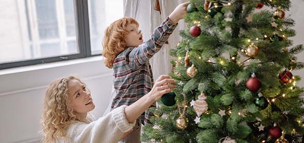 Kinder lieben den Weihnachtsbaum und helfen gerne ihn zu schmücken