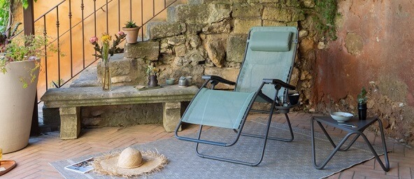 GUNST-gartenmöbel: Relaxliegestuhl in Salbeigrün auf einer mediteran anmutenden Terrasse.