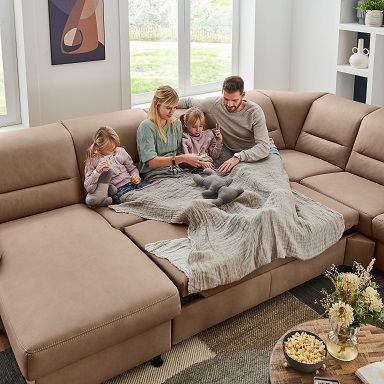 GUNST Polster-Express-Tage: Wohnlandschaft in hellem Sandton mit ausgeklappter Bettfunktion.
