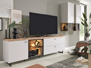 Moderne Wohnwand mit weißem Korpus und signifikanter Elementen aus hellem Holz.