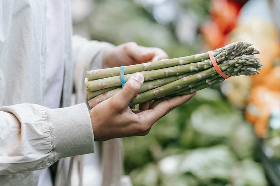 Frischer grüner Spargel in der Hand, ideal für ein Spargel-Rezept