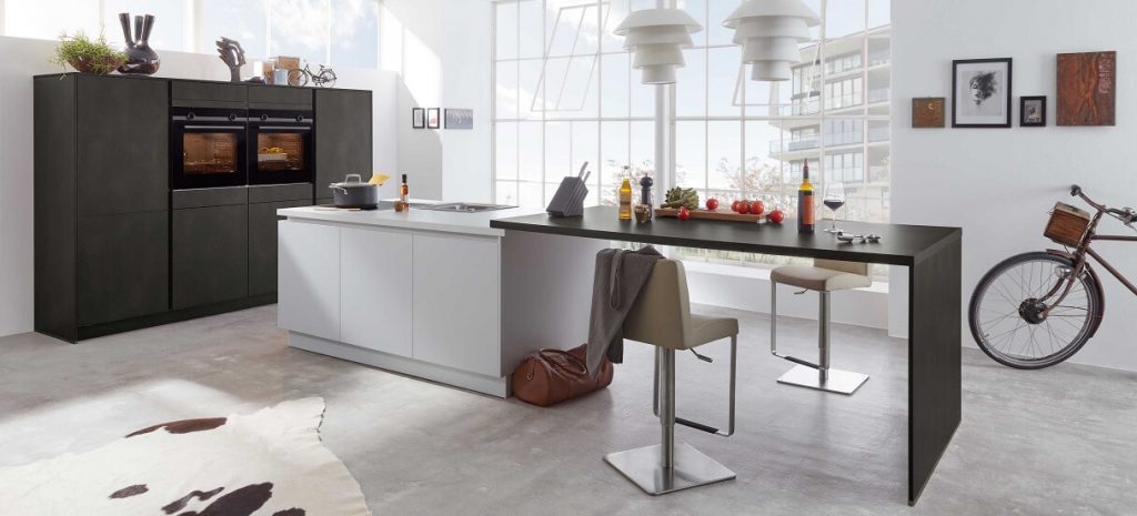 Design-Küche mit halbhohen Küchenschränke in Rost-Optik in Kombination mit einer Kücheninsel und angesetzterm langem Thekentisch. 