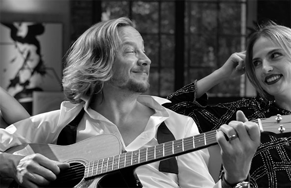 Sänger Samu Haber spielt auf der Interliving-Couch auf seider Gitarre