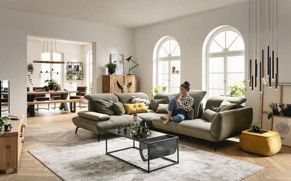 Ein großzügiger Wohn-Essbereich mit einladendem Sofa und einer modernen Essgruppe im Hintergrund.