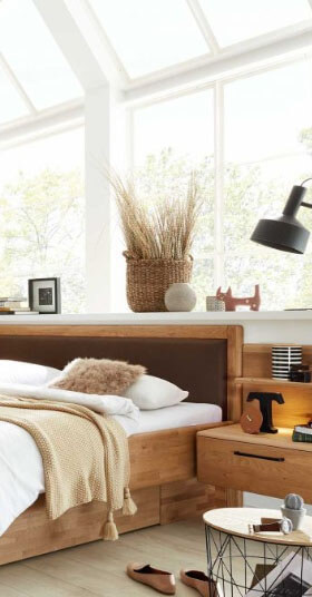 Der Bildausschnitt zeigt ein Schlafzimmer mit lederbezogenem Kopfteil und schwebenden Nachtkonsolen.