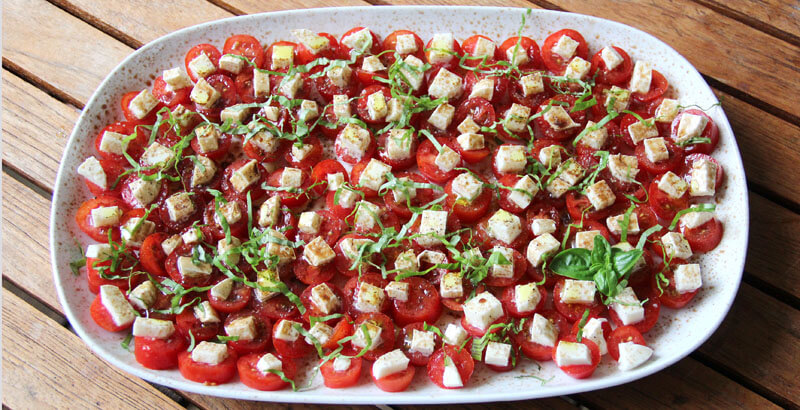 Insalata Caprese mit Bfeinen Basilikum-Streifen garniert.